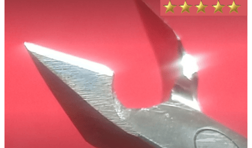Um alicate de cutícula amolado e polido em um fundo vermelho