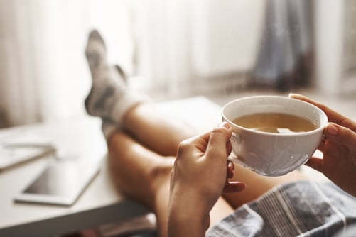 a person sitting on a couch with a cup of coffee