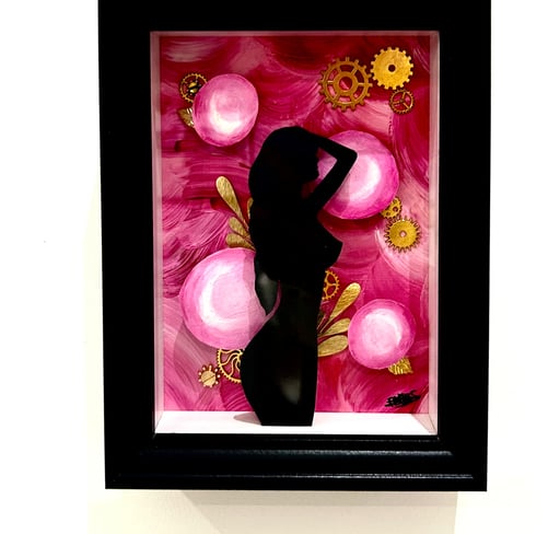 a woman in a black dress standing in front of a pink flower