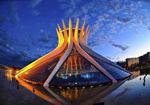 Catedral Metropolitana de Brasília iluminada pelo sol ao final do dia com céu azul ao fundo