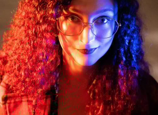 a woman with glasses in red and blue light
