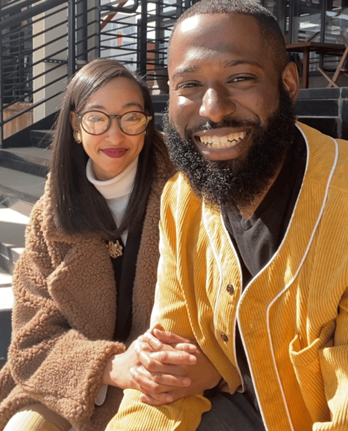 a man and woman sitting on stairs smiling