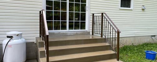 a house with a white door and stairs leading to a patio