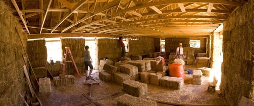 a group of people working on hay bale bale