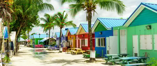 a row of colorful beach huts in the sand