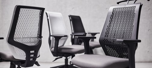 Row of T145 clerical chairs with perforated plastic backs in black and white finish