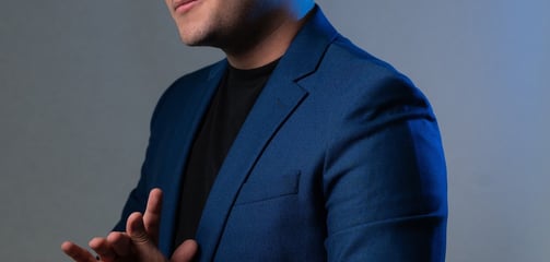 a man in a blue suit and black shirt