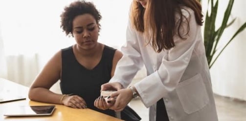 Foto da psicóloga ajudando paciente mulher a abrir uma caixa em dinâmica de psicologia