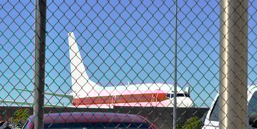 a plane is parked in front of a fenced in area