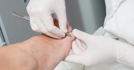 Professionele behandeling van een voet door een medisch pedicure.