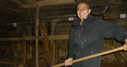 Zayera cleaning the cow stable in Switzerland