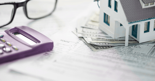 a calculator and glasses on a table that relates to individual tax preparation