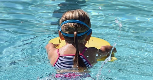 young child learning to swim