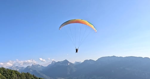 a person parasailing over a mountain