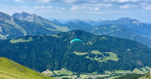 un parapentiste au milieu des montagnes