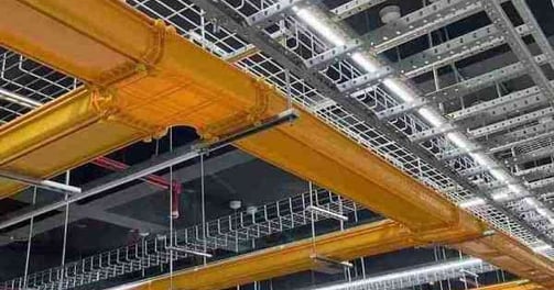 a ceiling with fiber cable trays and wire mesh cable tray and a ceiling light