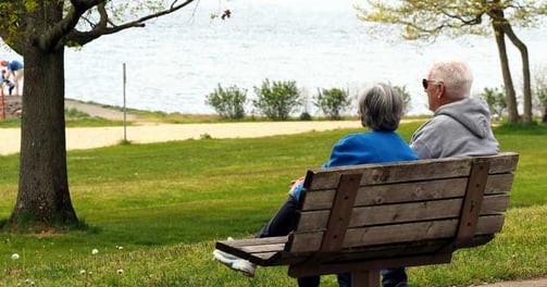 Anziani sereni su una panchina in un parco, simbolo di una pensione tranquilla e pianificata