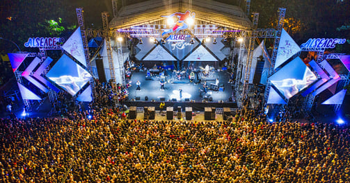 a large crowd of people standing around a stage