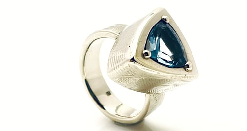 a ring with a blue TOPAZ and white GOLD