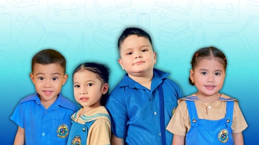 Shelomith pre-elementary students smiling in uniform with school-themed light blue background.