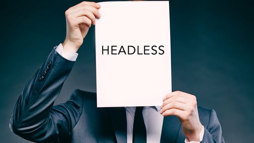 image of man holding piece of paper with "headless" written upon it