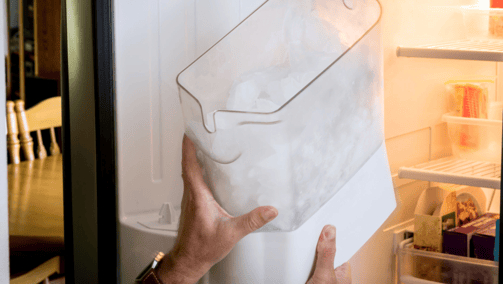 a person holding a piece of paper in front of a refrigerator