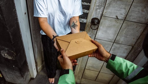 un homme tendant une boîte de repas à une femme