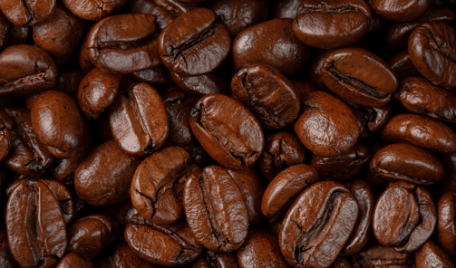 a close up of a pile of dark roast coffee beans