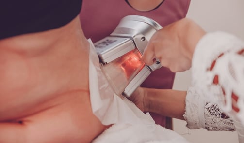 a woman having a cryolipolysis treatment at an aesthetic clinic