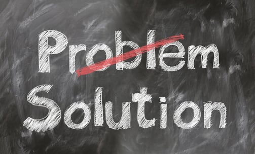 A blackboard with the word Problem crossed out and Solution written underneath