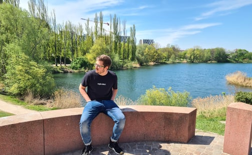 a man sitting on a bench in front of a lake