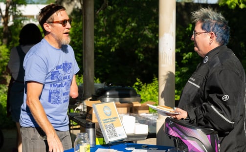 Two people talking over a table with printed resources on it