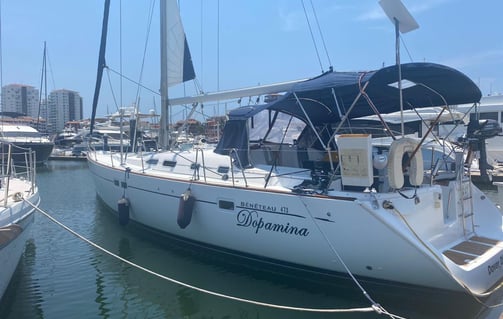 a sailboat docked at a marina with a boat in the water