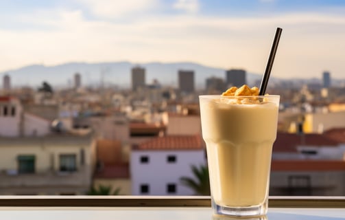 a glass of horchata with Valencia's skyline in the background