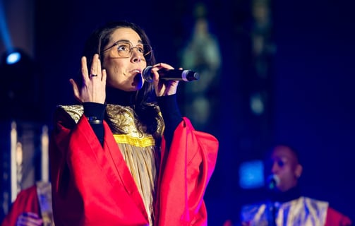 une femme en robe rouge et lunettes chantant du gospel