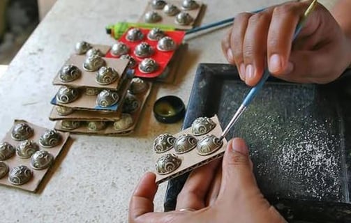 a person is using a pair of scissors to cut a button