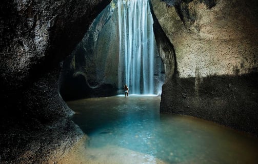 a person standing in front of a waterfall