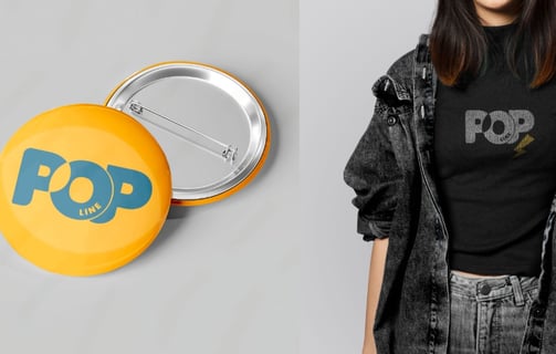Mulher vestindo uma camisa preta ao lado dois botons (pins) amarelos com a palavra "pop" estampada