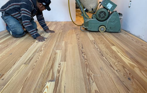 a man is using a machine to remove wood flooring
