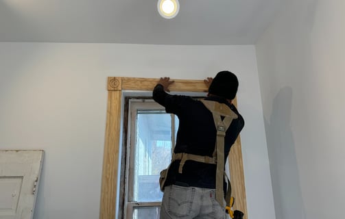 a man is standing on a ladder and holding a light bulb