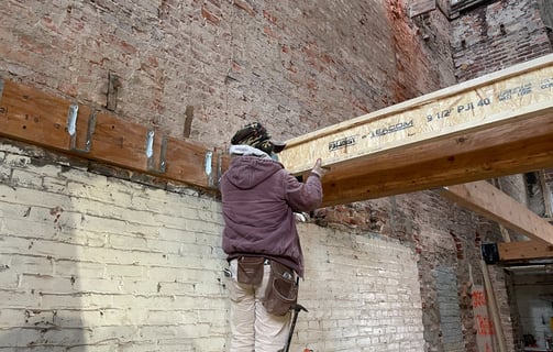 a man is working on a beam of wood