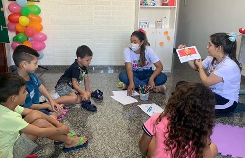 a group of children sitting on the floor in a circle