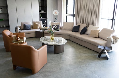 Contemporary living room with neutral tones, curved chairs, and mixed textures. A calm space layered with personality.