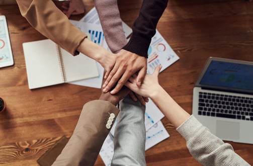 a team of managers bringing hands together in a circle