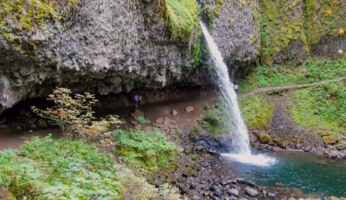 Columbia River Gorge - ponytail falls flows out over a cliff overhang into a blue/green pool