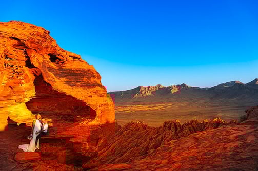 wedding couple sitting on red rocks