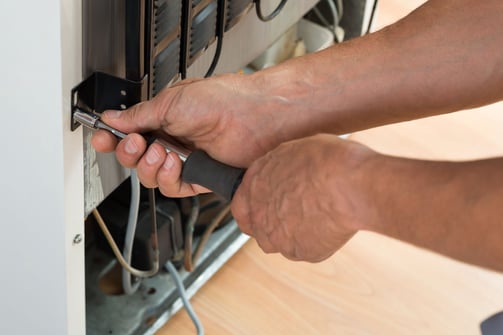 a man is fixing a dishwasher in a dishwasher