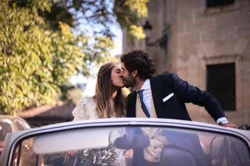 portrait intemporel de mariés debout dans leur voiture de mariage, ambiance élégante et sobre