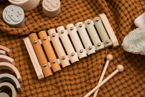 a musical instrument with a wooden mallet and a teddy bear