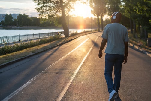 a man skateboarding down a street in the sun